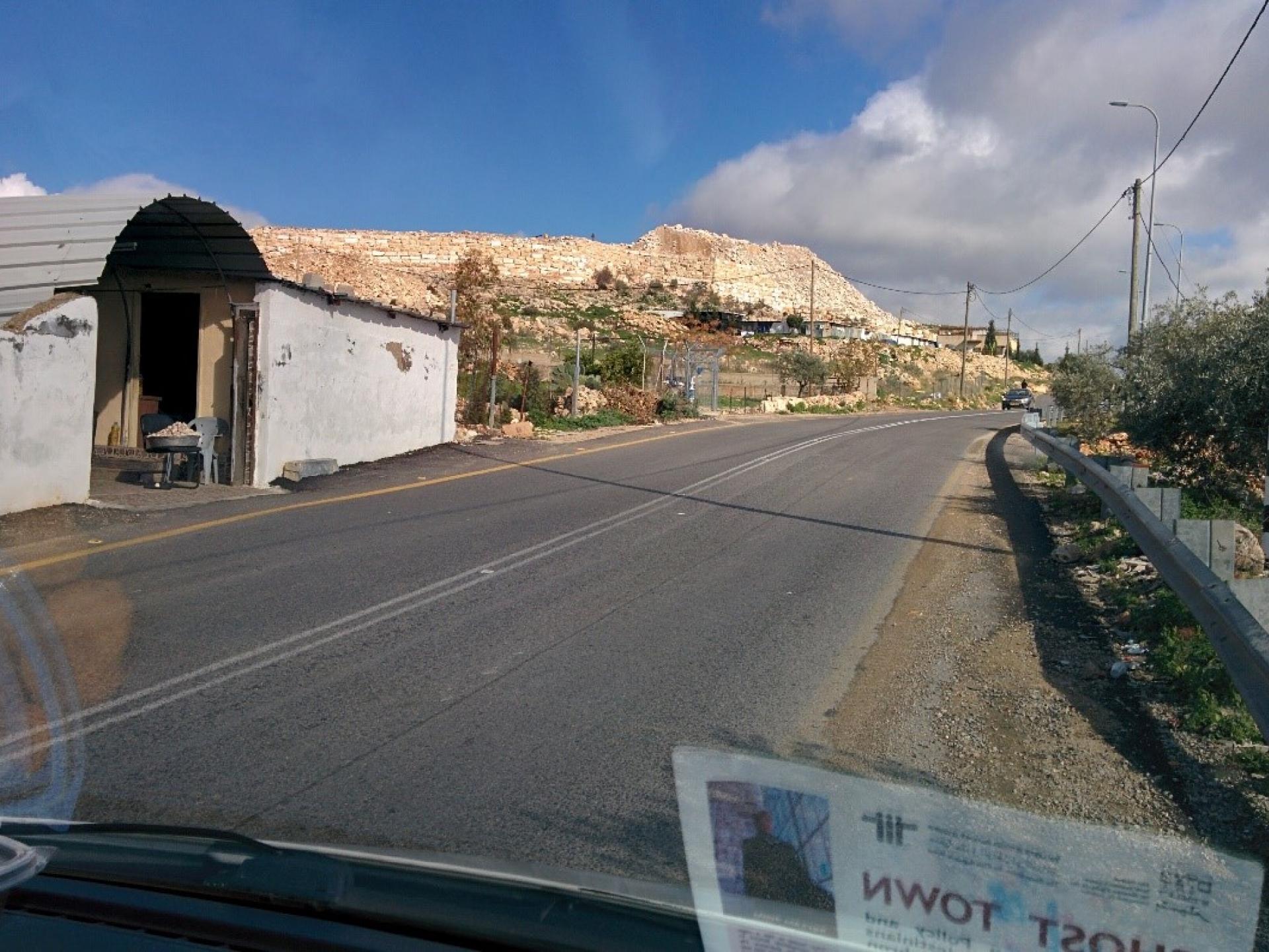 Road 446: the entrance to the family shop against the background of the Leshem Fort wall nearly completed