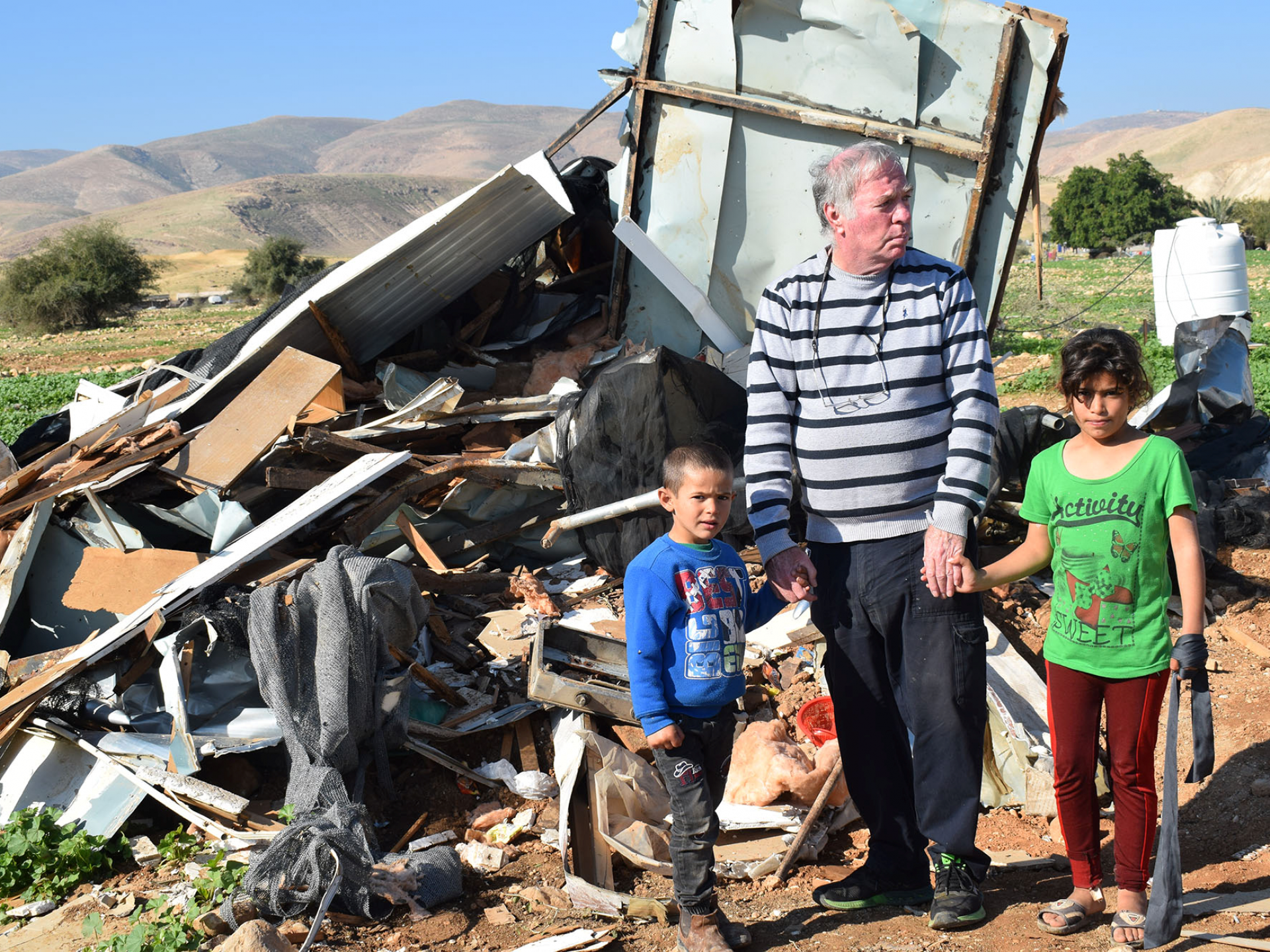 Buma Inbar and the family's children with the destroyed home in the background