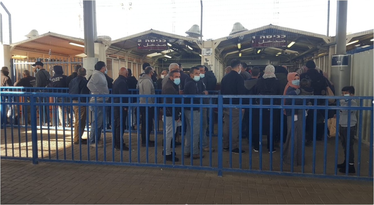 אנשים עומדים בין סורגים בכניסה למחסום