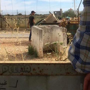 נער פלסטיני מלקט מהאשפה בקבוקים ופחיות למִחזור