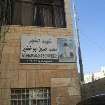 שלט קטן עם תמונת הילד הרצוח, מוחמד אבו-ח'דיר