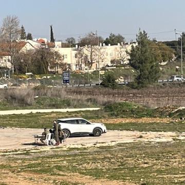 שלושה חיילים יושבים בשדה ריק, עסוקים מכדי לטפל בפלסטינים במת"ק עציון
