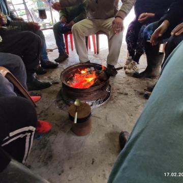 A meeting of friends in Farsia around an improvised wood stove